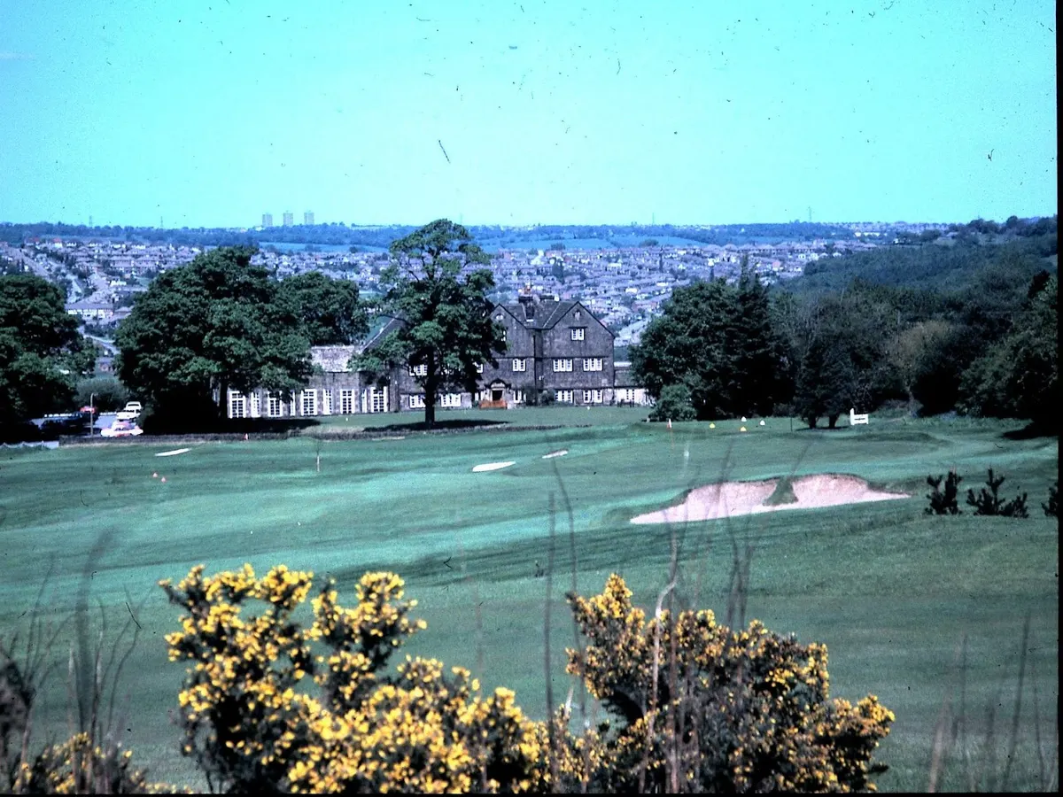 The Hallowes Golf Club clubhouse, a vintage photograph showing the stone building on the golf course with trees in the background.