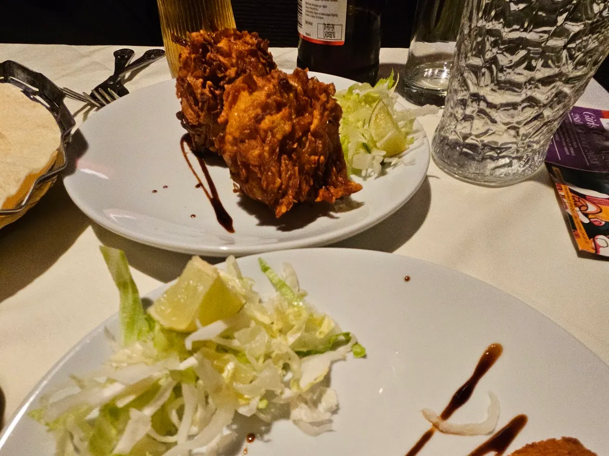 A fragrant curry dish with diced vegetables and fresh herbs presented artfully on a plate alongside accompaniments.