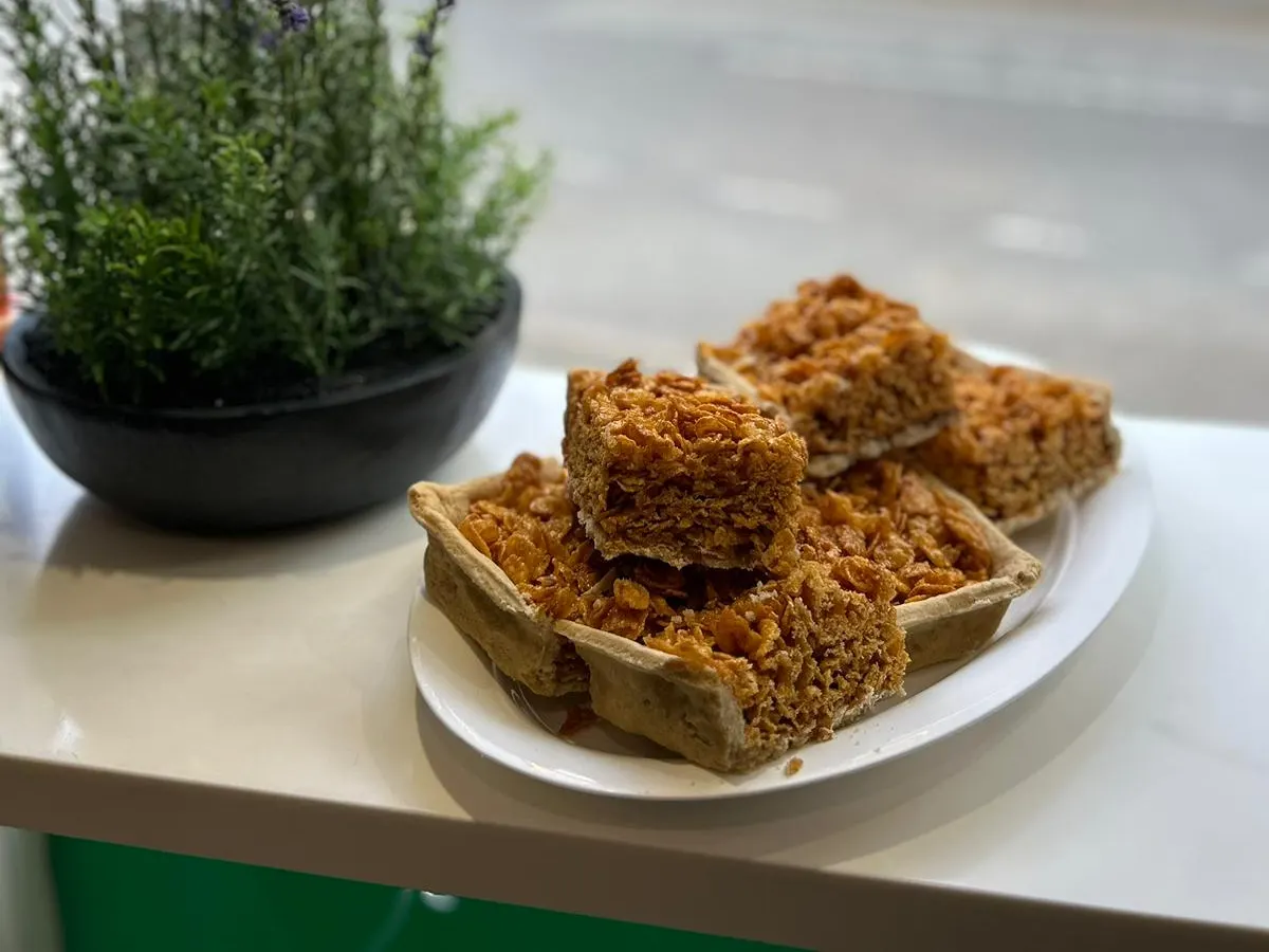 A fried chicken sandwich with lettuce and sauce on a white plate.