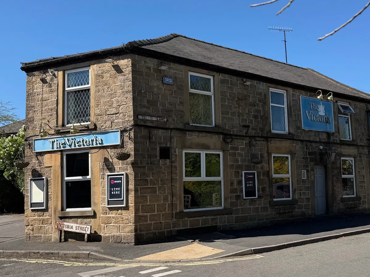 The Victoria Inn pub exterior on Victoria Street, showing stone building with blue signage and traditional architecture.
